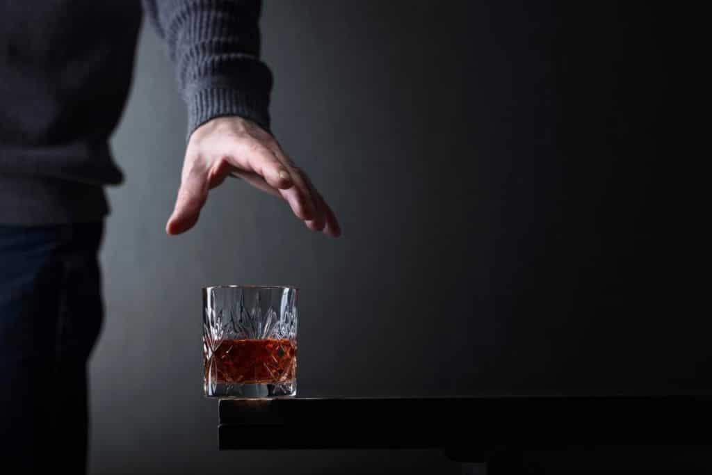 hand reaching for alcoholic drink