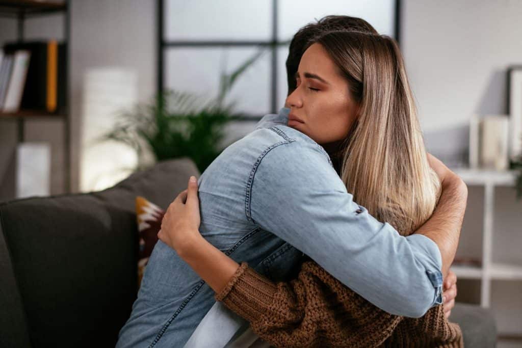 woman hugging man in support after discussing the 5 signs of cocaine addiction
