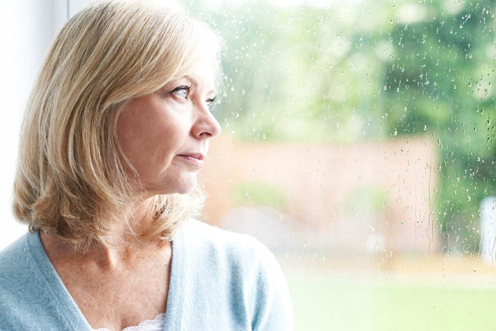 young woman outside and staring into the distance wondering what the physical signs of meth addiction look like in a loved one