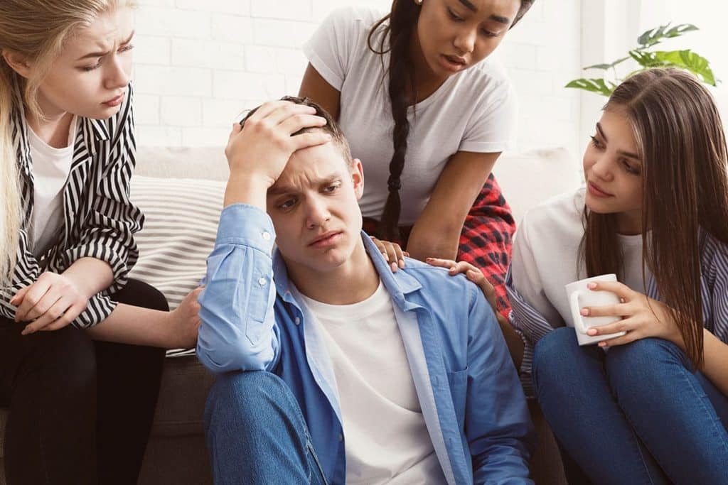 concerned group of friends helping distraught person understand how do you send someone to rehab