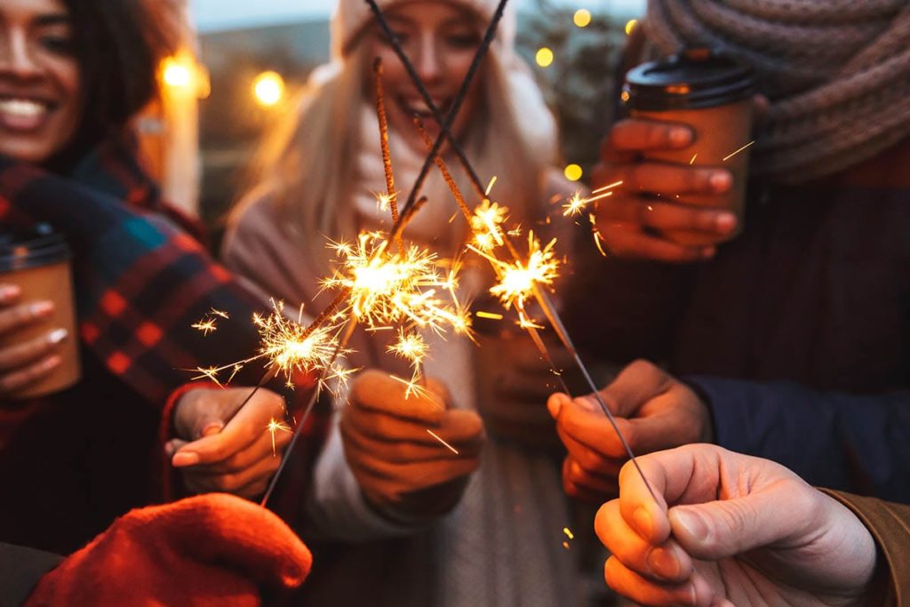 group of friends holding sparklers and celebrating a sober new year's eve