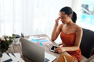 woman sitting at the computer with a headache
